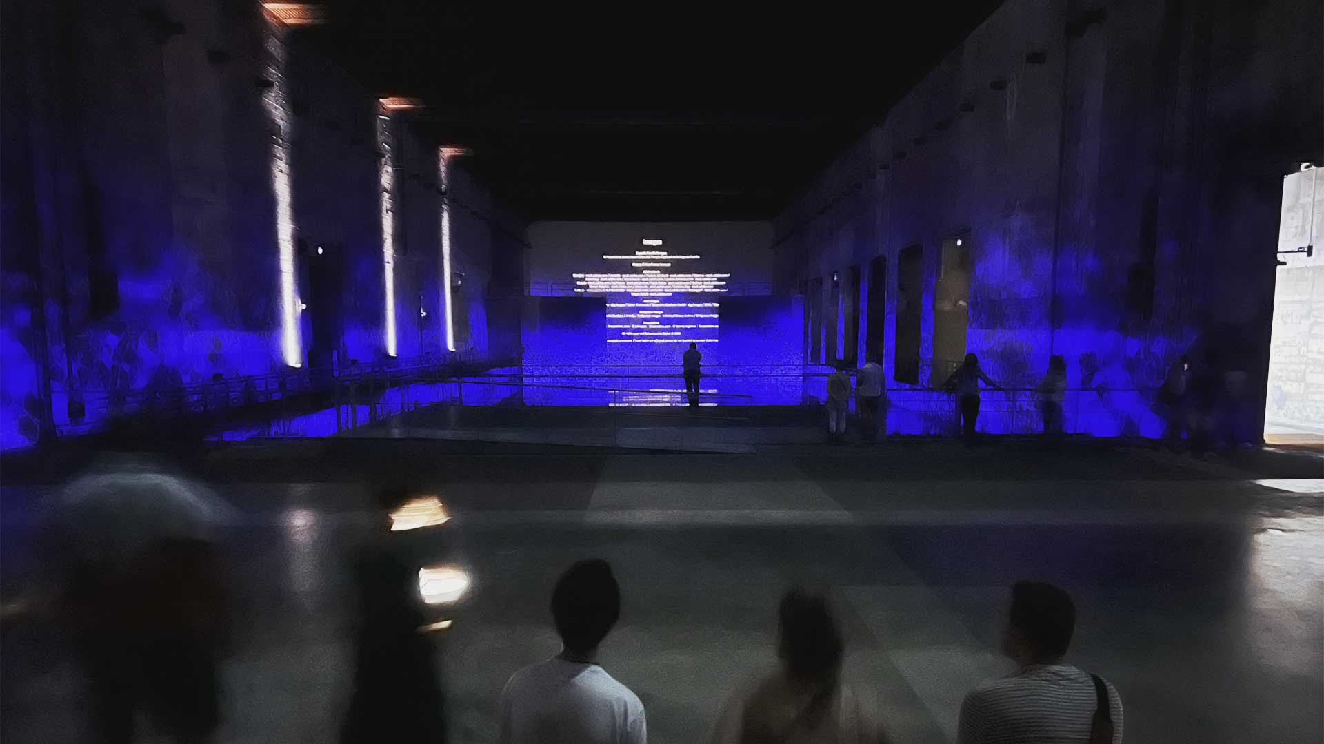 Digital art projected on a wall in a submarine pen event space