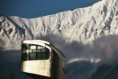 futuristic building in front of snowy mountains