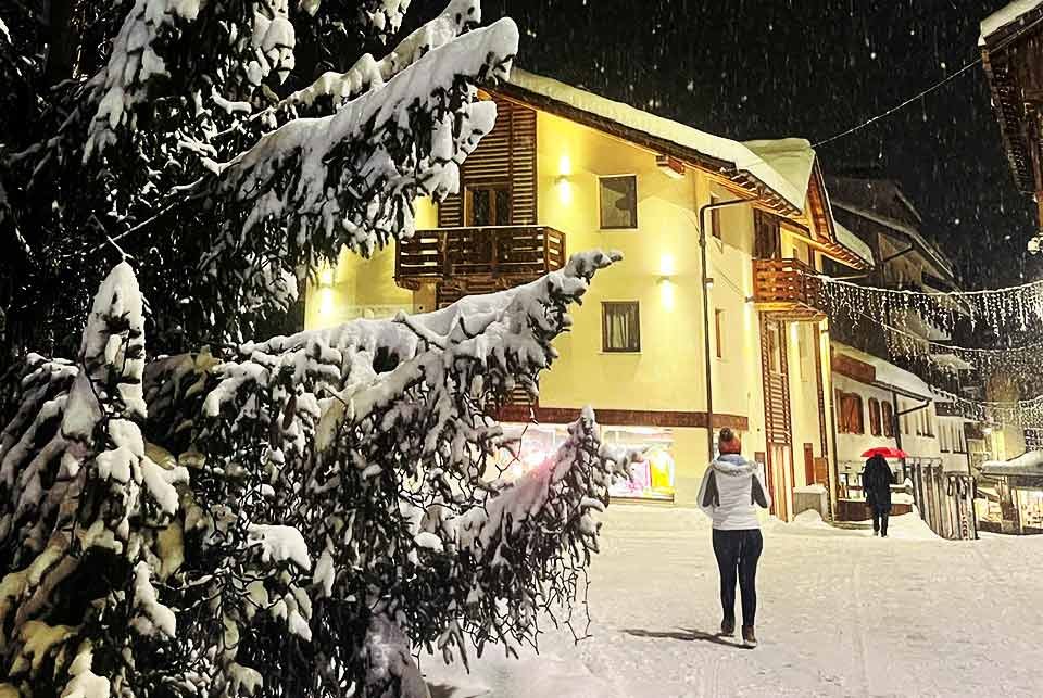 people walking at night on a snowy street