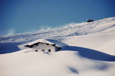 mountain hut covered in snow