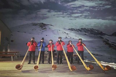 A band of horn players on a mountain terrace