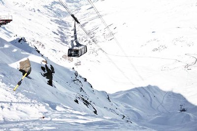 Cable car ascending a snowy mountain